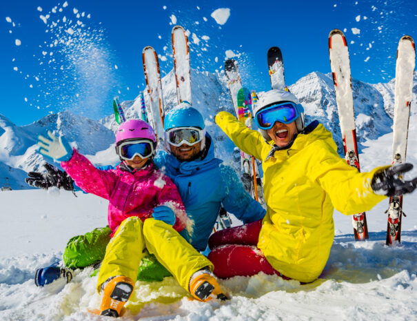 Happy family enjoying winter vacations in mountains. Playing with snow, Sun in high mountains. Winter holidays.